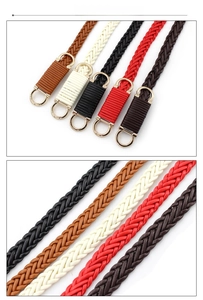 Dettaglio di cinture in pelle intrecciata in cinque colori con fibbie dorate e trama