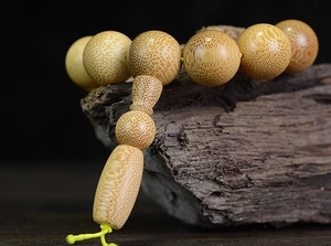 Detailed view of natural dragon blood bamboo beads with fine texture on dark wood