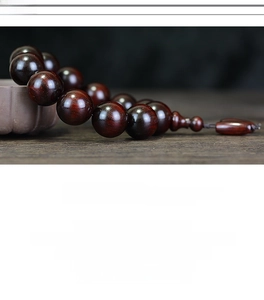 Macro detail of high-density red sandalwood beads with natural wood grain and polished finish
