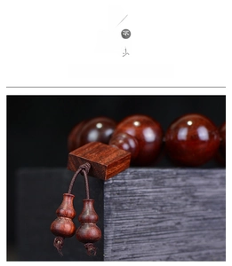 Macro view of polished red sandalwood prayer beads with wooden pendant and fine grain