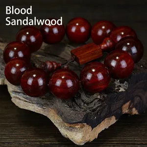 Polished red blood sandalwood Buddhist prayer beads bracelet on rustic wood background