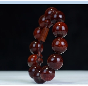 Macro shot of polished redwood prayer beads showing fine wood grain and high gloss finish