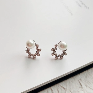 Elegant 925 sterling silver pearl stud earrings with zircon floral accents on book pages