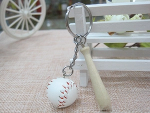 Detail of mini baseball and wooden bat keychain with red stitching on a white display