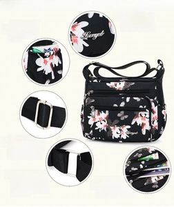 Detail view of floral nylon crossbody bag showing multiple zippers and side pockets