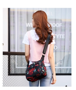 Detail of floral printed nylon crossbody bag with adjustable strap on female model