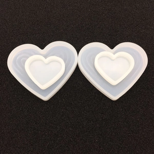 Detail showing two heart-shaped silicone resin molds with nested design on black background