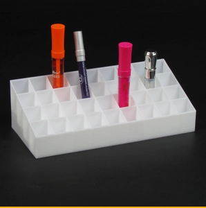 Detailed view of a white multi-slot acrylic lipstick organizer for desktop storage