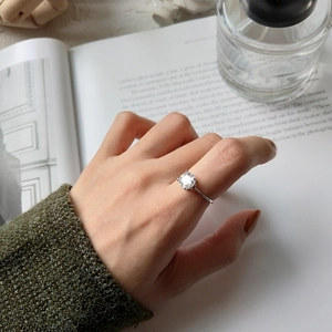 Elegant S925 sterling silver four-prong solitaire ring worn by a model in a minimal setting