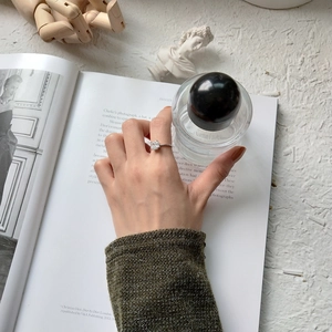 Detail showing an elegant S925 silver ring with a large square-cut sparkling solitaire