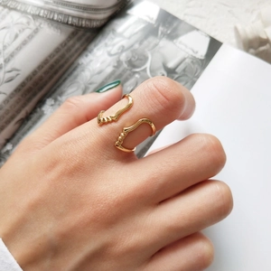 Artistic gold face silhouette open ring worn by model on a stylish fashion magazine