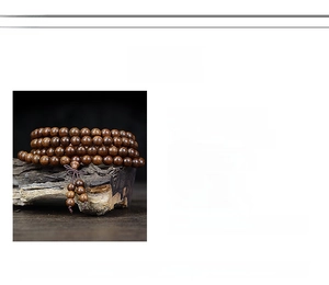 Detailed view of 108 Golden Sandalwood prayer beads with fine grain and elegant texture