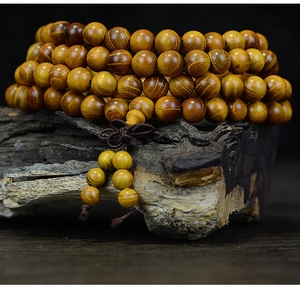Vue macro d'un chapelet de 108 perles en bois de santal avec grain naturel sur bois