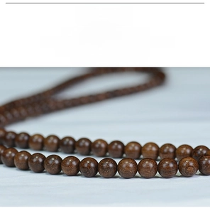 Macro shot of polished sandalwood beads showing natural grain and smooth texture