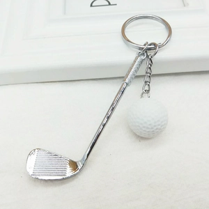 Detailed close-up of a golf club and ball keychain with silver metallic finish and ring