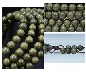 Detailed close-up of 108 ebony wood prayer beads showing natural grain and silk knot
