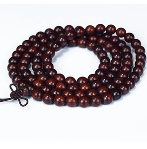 Detailed close-up of 108 high-density dark brown sandalwood prayer beads with a Chinese knot