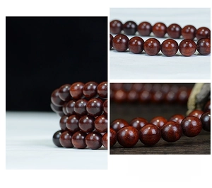 Macro shot of polished 108 sandalwood prayer beads showing natural wood texture and grain