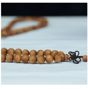 Macro detail of natural sandalwood beads bracelet with an elegant dark brown Chinese knot