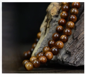 Macro shot of 108 black rosewood prayer beads showing natural wood grain and zen aesthetic