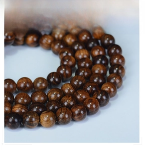 Detailed macro view of 108 high-polished dark brown rosewood beads with fine wood grain