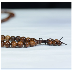 Macro shot of dark brown wooden beads showing natural grain and polished texture detail