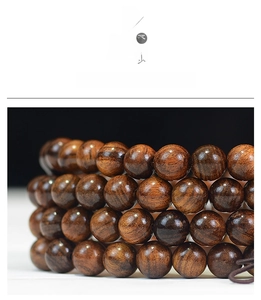 Macro shot of 108 dark rosewood prayer beads with natural wood grain and polished finish