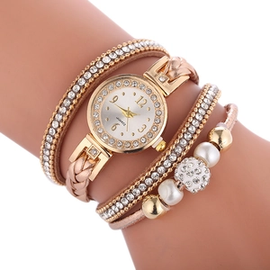 Montre bracelet multicouche or rose ornée de cristaux et perles sur un bras mannequin