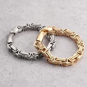Men's titanium steel Byzantine chain bracelets in gold and silver finish on stone background