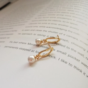 Detail of 925 silver irregular gold pearl earrings on a vintage literary book page