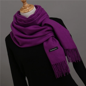 Close-up of a deep purple cashmere scarf with soft fringes and a sewn cashmere label