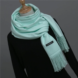 Close-up of mint green cashmere shawl featuring high-quality weave and fringe details