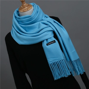 Detail of bright blue cashmere scarf showing soft texture and elegant long fringe tassels
