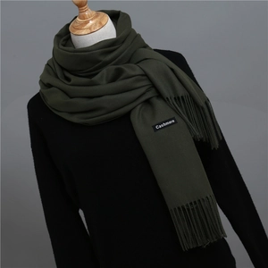 Detail shot of army green cashmere scarf showing fringe and authentic material label