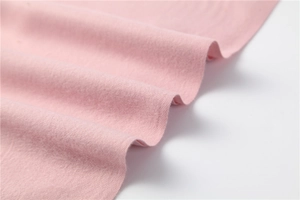 Close-up of soft pink cashmere-like fabric texture showing fine brushed fibers and warmth