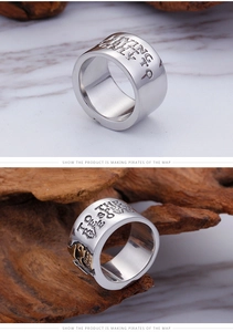 Close-up of punk style steel ring with vintage engraved text and skull relief detail