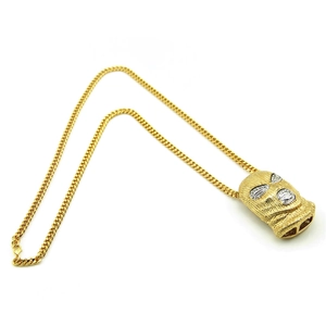 Macro shot of gold hip-hop balaclava pendant with crystals and classic cuban chain