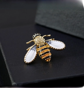 Macro shot of bee brooch with golden base, enamel wings and sparkling rhinestones