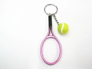 Detail of a pink miniature tennis racket and yellow felt ball keychain on white backdrop