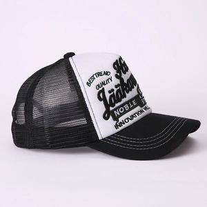 Detail of black and white trucker hat featuring high-quality embroidery and breathable mesh