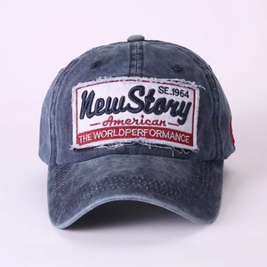 Detailed close-up of vintage embroidery patch on washed navy blue cotton baseball cap