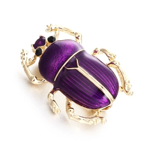 Macro de la broche scarabée vintage en émail violet et détails en strass dorés