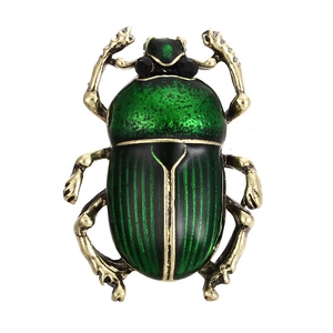 Broche scarabée vintage verte avec pattes dorées et cristaux sur fond blanc épuré