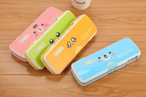 Top view of four colorful plastic pencil cases with cute animal patterns on a wood desk