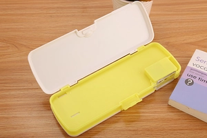 Detail view of an open plastic pencil case with a built-in pencil sharpener on a desk