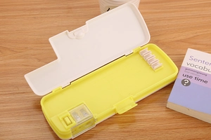 Detail of creative double-open yellow pencil case with built-in sharpener and pen slots