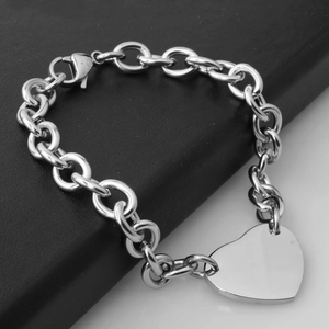 Silver chain bracelet with heart pendant and lobster clasp on dark textured background