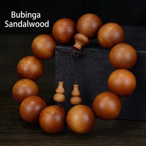 Barbi Sandalwood 12-bead Buddhist bracelet with traditional gourd pendant on dark wood base