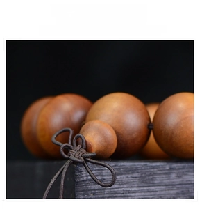 Macro shot of polished brown sandalwood beads with a traditional woven Chinese knot