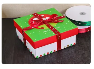 Detail of red Merry Christmas ribbon bow on a green and white festive holiday gift box